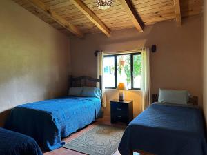 a bedroom with two beds and a window at Cabaña el nido del monte in Tapalpa