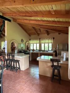 a large kitchen with wooden ceilings and bar stools at Cabaña el nido del monte in Tapalpa