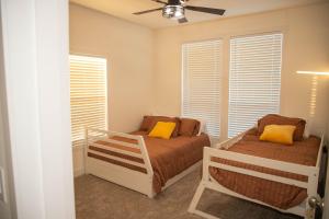 a bedroom with two beds and a ceiling fan at Rural Farmhouse in Taylor