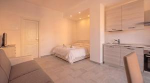 a small bedroom with a bed and a kitchen at Dimoras Central Studio 4 Guests Parking in Olbia +3 photos