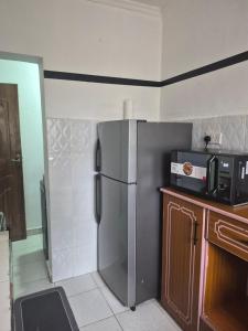 a kitchen with a stainless steel refrigerator and a microwave at Maroon House in Narok