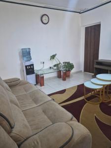 a living room with a couch and a table at Maroon House in Narok +1 photo