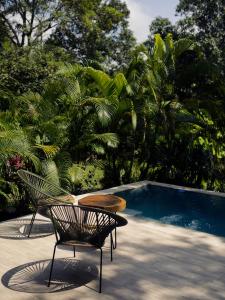 a chair and a table next to a swimming pool at Kantawa Refugio de Bienestar in El Zaino