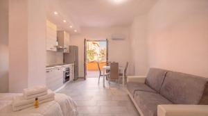 a living room with a couch and a kitchen and a table at Dimoras Central Studio 4 Guests Parking in Olbia