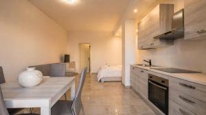 a kitchen with a table and a counter top at Dimoras Central Studio 4 Guests Parking in Olbia