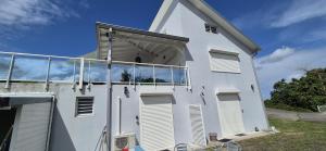 a white building with white shutters on it at location studio in Ducos
