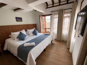 a bedroom with a bed with two towels on it at Hotel Boutique Cenit in Villa de Leyva