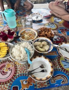 a table topped with dishes of food on a table at Batu Mela Cottage in Banggai