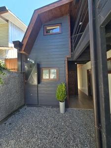 a house with a garage with a potted plant in front at Palguin pad loft # 1 in Pucón