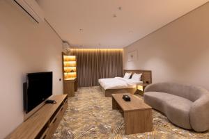 a large hotel room with a bed and a television at فندق أجنحة رواق in Medina