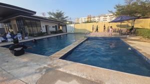 a swimming pool with people playing in the water at Plumera Mactan Condominium near Airport in Bankal