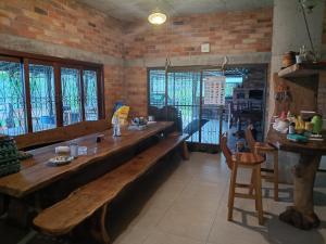 a dining room with a long wooden table and chairs at Sítio dos Nogueira in Pará de Minas