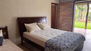 a bedroom with a bed and a brick wall at Sítio dos Nogueira in Pará de Minas +9 photos