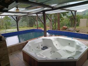 a bath tub sitting next to a swimming pool at Sítio dos Nogueira in Pará de Minas