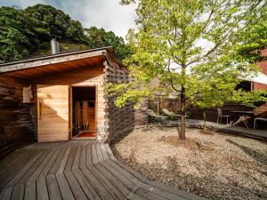 ein kleines Gebäude mit einem Baum davor in der Unterkunft Kasan in Kirishima