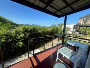 a white bench sitting on the deck of a house at Nordic Mountain View in Ban Khlong Chi Lat