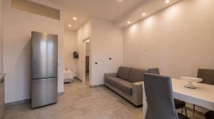 a kitchen with a couch and a table and a refrigerator at Dimoras Central Studio 4 Guests Parking in Olbia