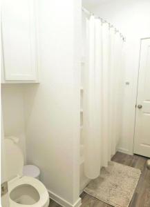 a white bathroom with a toilet and a shower at Luxe Haven in Richmond