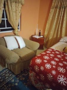 a living room with a chair and a ottoman at Carol Resident in The Grove