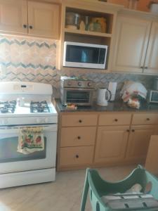 a kitchen with a stove and a microwave at Carol Resident in The Grove