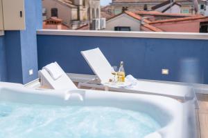 a hot tub with two chairs and a table with drinks at Spaccavento Boutique Rooms in Chioggia