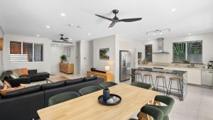 a living room with a couch and a table at Sandveil Absolute Beachfront Access House in Trinity Beach
