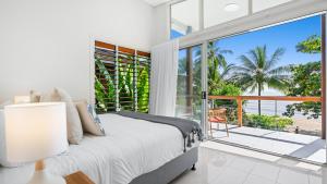 a bedroom with a bed and a view of the ocean at Sandveil Absolute Beachfront Access House in Trinity Beach
