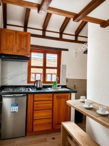 a kitchen with a stainless steel stove and wooden cabinets at Boutique La Gloria in Villa de Leyva