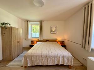a bedroom with a bed and a window at Traunzeit Apartment in Ebensee