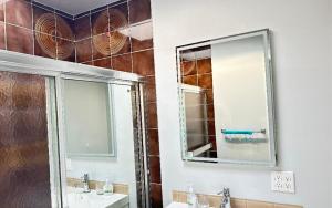 a bathroom with a shower and a sink and a mirror at Joe West Vancouver Lodge in West Vancouver
