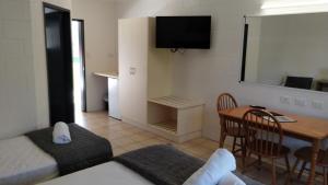 a room with a bed and a desk and a table at Tully Motel in Tully