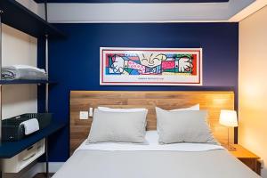 a bedroom with a bed with a blue wall at Flat Hotel Sena Madureira_Ibirapuera (Apto 708) in São Paulo +34 photos