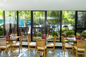 a restaurant with tables and chairs and windows at Flat Hotel Sena Madureira_Ibirapuera (Apto 708) in São Paulo