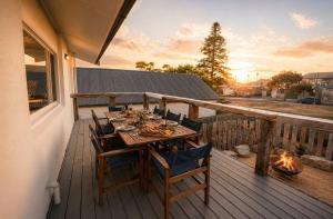 a wooden table and chairs on a deck with a fireplace at Central Goolwa- Coastal Family & Friend Retreat in Goolwa