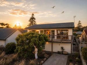 a woman standing on the balcony of a house at Central Goolwa- Coastal Family & Friend Retreat in Goolwa