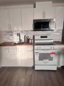 a white kitchen with a stove and a sink at Peace House in Bills Island