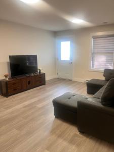 a living room with a couch and a flat screen tv at Peace House in Bills Island