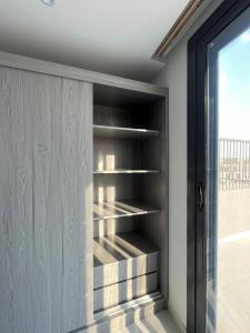 a closet with wooden shelves in a room at Modern Rooftop with Stunning View Iconic Tower in Madīnat aţ Ţalāʼi‘