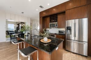 a kitchen with wooden cabinets and a stainless steel refrigerator at Diamond Beach in Galveston