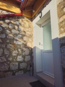 a door in a stone wall with a window at Apartmani PASHA in Nikšić +45 photos