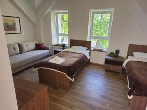 a living room with a bed and a couch at Apartmani PASHA in Nikšić