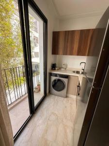 a kitchen with a sink and a washing machine at Diyafa Invest in Oulad Akkou
