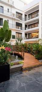 a building with a wooden bridge and a pond in front at Diyafa Invest in Oulad Akkou