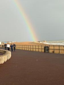people walking along the beach with a rainbow in the background at Dickens HideAway in Hollington