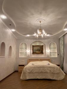 a bedroom with a large bed and a chandelier at Castle Apartments in Schaslyve