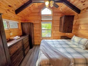 a bedroom of a log cabin with a bed and cabinets at Tiny Home Topline in Carroll