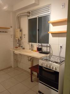 a kitchen with a stove and a sink at Apt Térreo in Resende