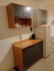a kitchen with a wooden counter and a refrigerator at Apt Térreo in Resende