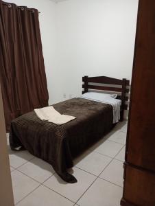 a bedroom with a bed with a brown blanket at Apt Térreo in Resende +1 photo