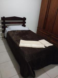a bed with two white towels on top of it at Apt Térreo in Resende